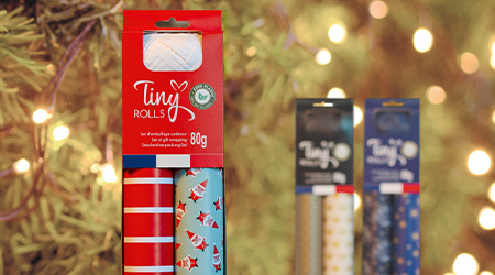Geschenkset Tiny Rolls-Geschenkpapier von Clairefontaine für Weihnachten, stehend vorm Tannenbaum.