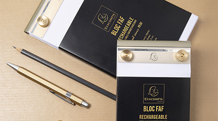 Metallischer FAF Block von Exacompta liegend auf braunem Kraftpapier. Daneben schwarzer Bleistift und goldener Kulli.