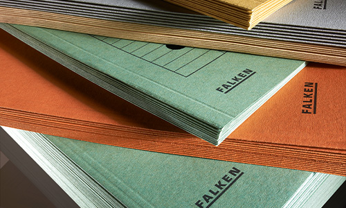 Es werden Stapel von Umlaufmappen von Falken aus Recycling-Karton in verschiedenen Farben, darunter Blau, Orange und Gold, ausgestellt. Auf den Einbänden ist der Name „Falken“ aufgedruckt. Die Umlaufmappen sind leicht überlappend angeordnet.
