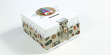 Eine dekorative, rechteckige weiße Box mit einem bunten, gemusterten Band mit Cartoon-Insekten. Sie hat einen silbernen Verschluss mit einem Vorhängeschloss und einem Schlitz an der Oberseite. Auf dem Deckel befindet sich ein rundes, verspieltes Gesichtsdesign.