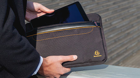 Mann in Anzug holt Tablet aus schwarzer Laptoptasche von Exacompta raus. Man sieht nur die Hände und Arme des Mannes.