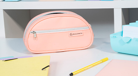 Rosanes, ovales Schlampermäppchen von Exacompta auf dem Schreibtisch mit weiteren Büroaccessoires.