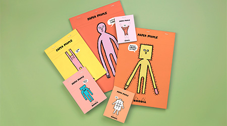 Blöcke von Rhodia mit Paper People von Jean Jullien auf dem Einband. Grüner Hintergrund.