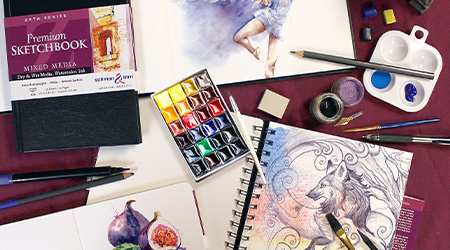 Tisch mit Skizzenbuch Mixed Media Zeta von Stillman&Birn, schwarzer Einband. Mit Stiften und Farbe. Offene Skizzenbücher mit Zeichnung eines Wolfs und Feige.