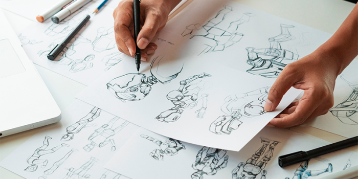 Mangaskizzen auf Storyboard-Mangapapier von Clairefontaine. Man sieht zudem zwei Hände, die eine Skizze halten, mit einer Hand wird gezeichnet.