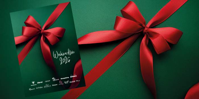 Eine rote Schleife auf grünem Hintergrund, darauf das Cover des Weihnachtskatalogs von Exaclair, auch mit roter Schleife und grünem Hintergrund.